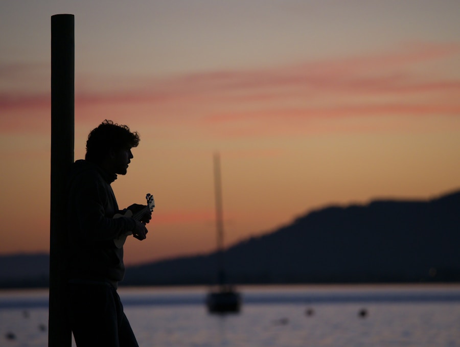 A man leaning against a pole at sunset.