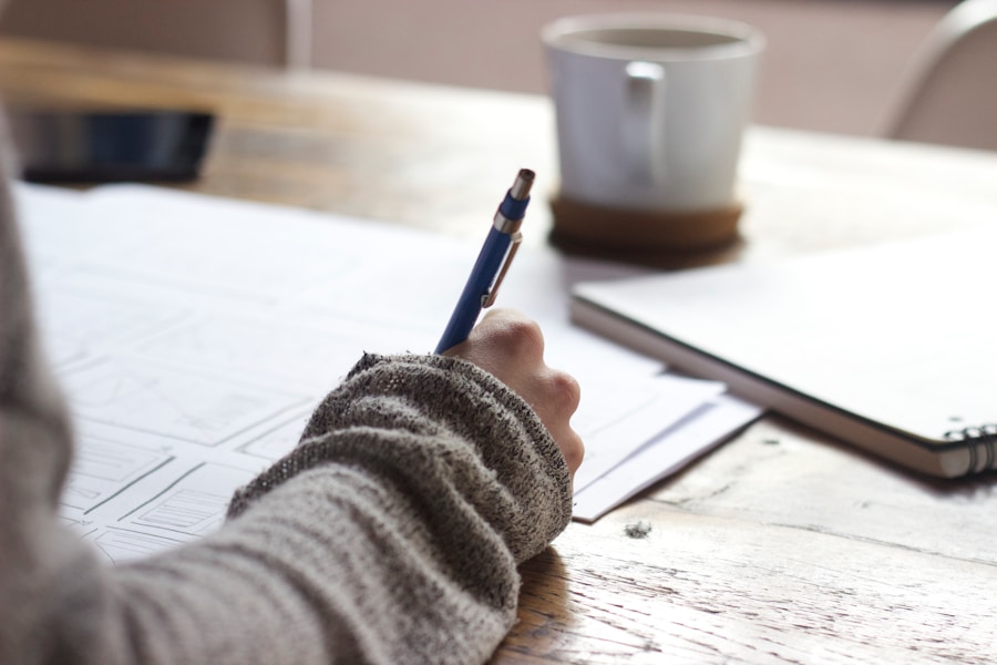 A person writing on a piece of paper at a desk.