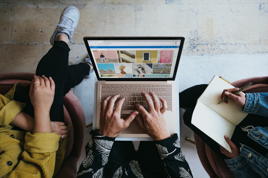 A group of people sitting around a laptop.