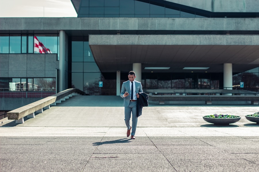 A businessman in a suit walking in front of a building.