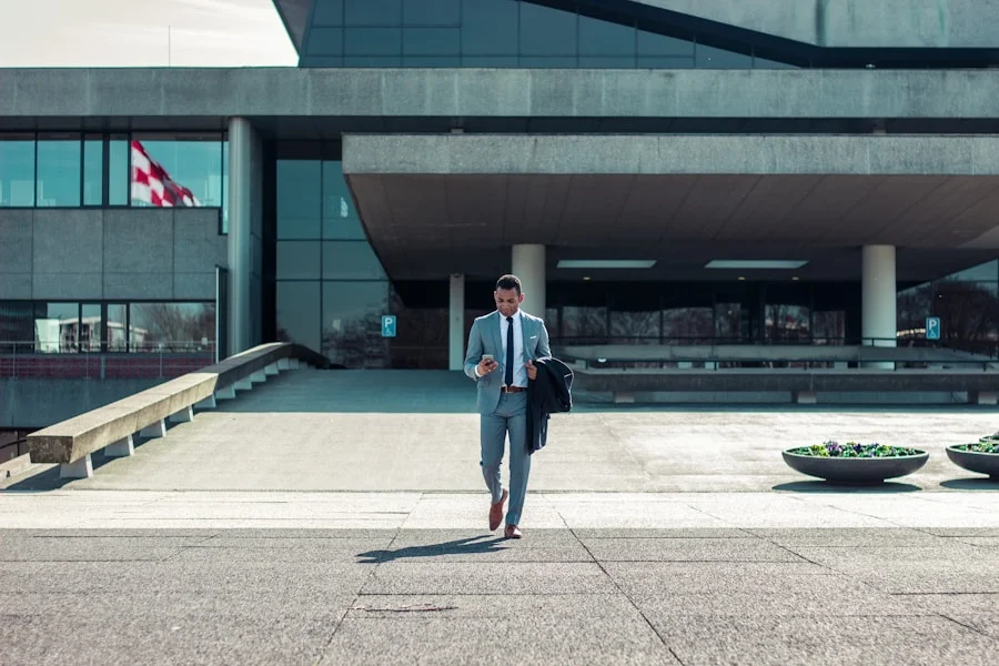 A businessman in a suit walking in front of a building.
