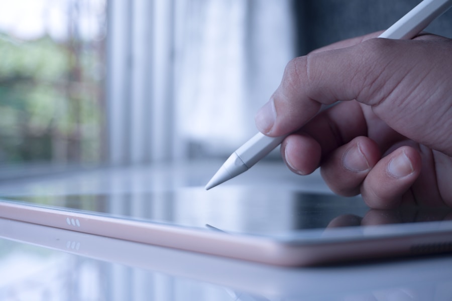 A hand is holding a pen on an ipad.