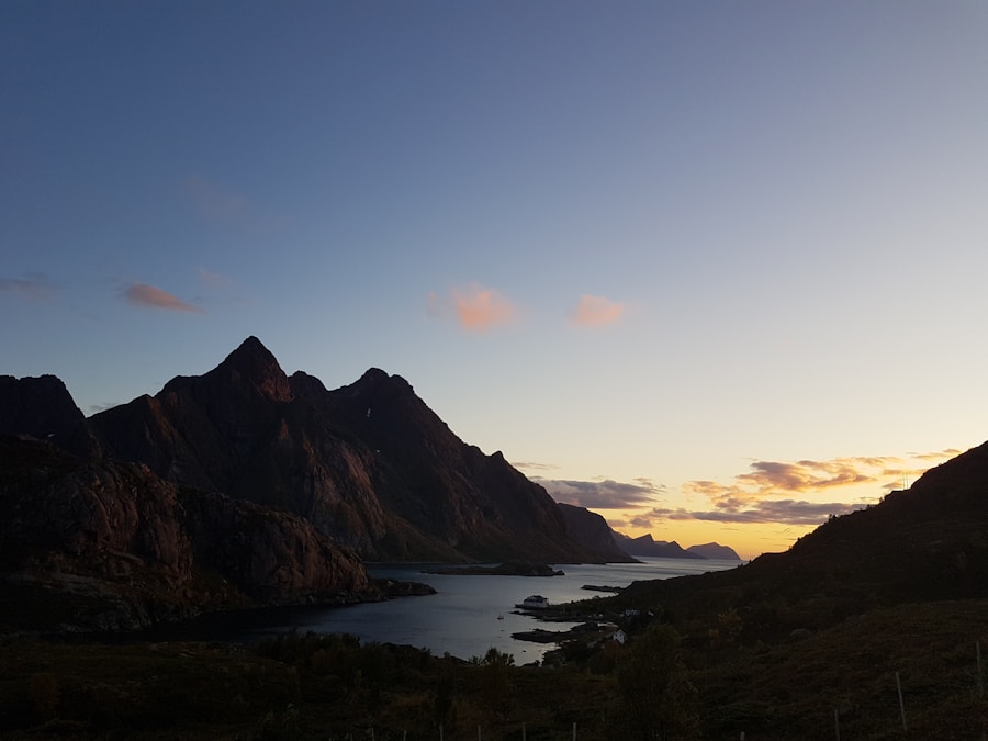 The sun is setting over a mountain range with a lake in the background.