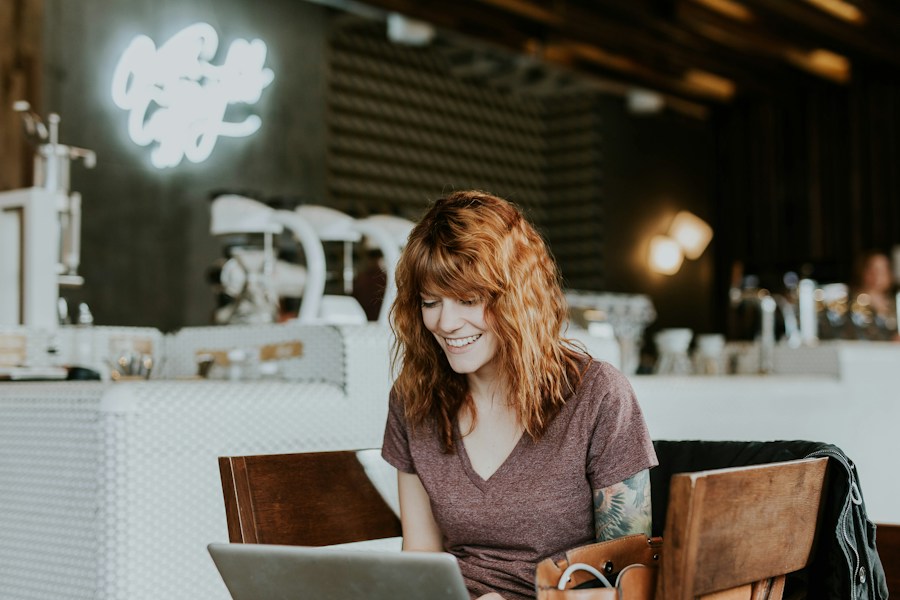 A woman working on a laptop in a coffee shop.