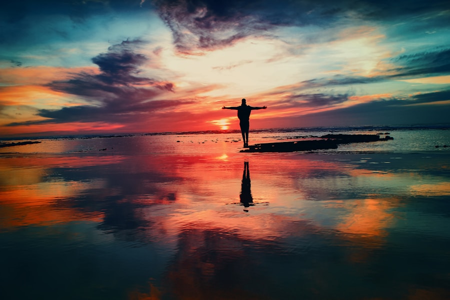 A person standing on a beach at sunset.