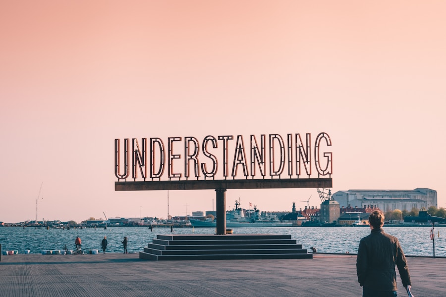 A man standing in front of a sign that says understanding.