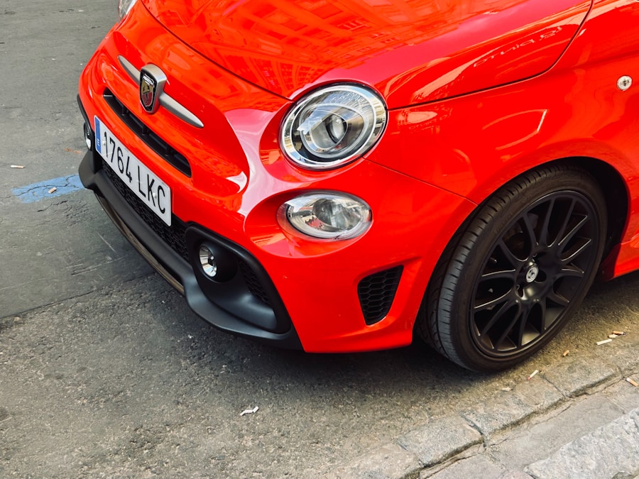 A red fiat 500 is parked on a street.