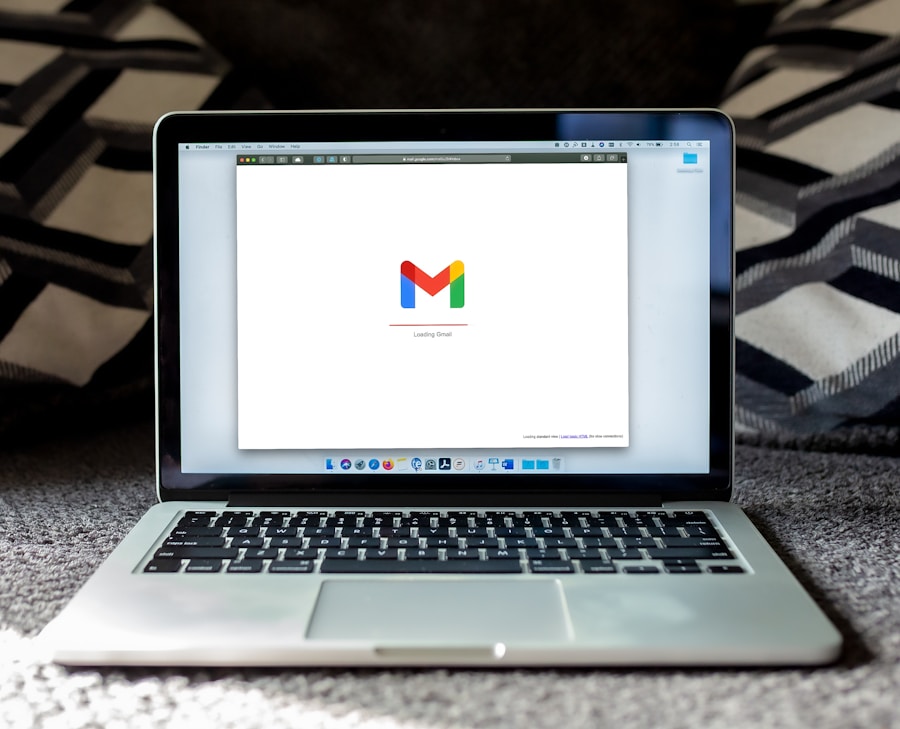 A laptop on a textured surface displaying the gmail loading screen.