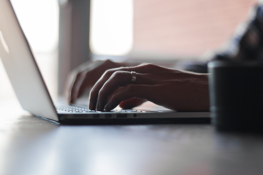 Close-up of a person typing on a laptop keyboard.