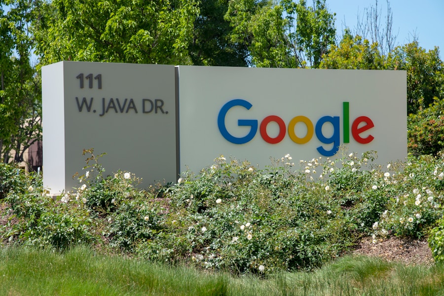 Google's corporate headquarters sign surrounded by greenery.