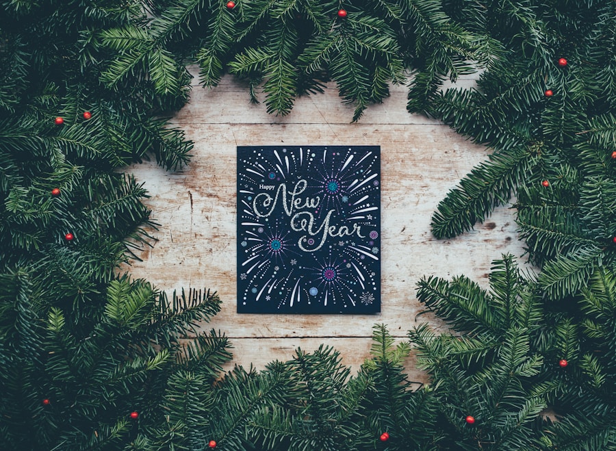 Fir branches arranged in a circular frame with a "happy new year" greeting card at the center on a wooden background.