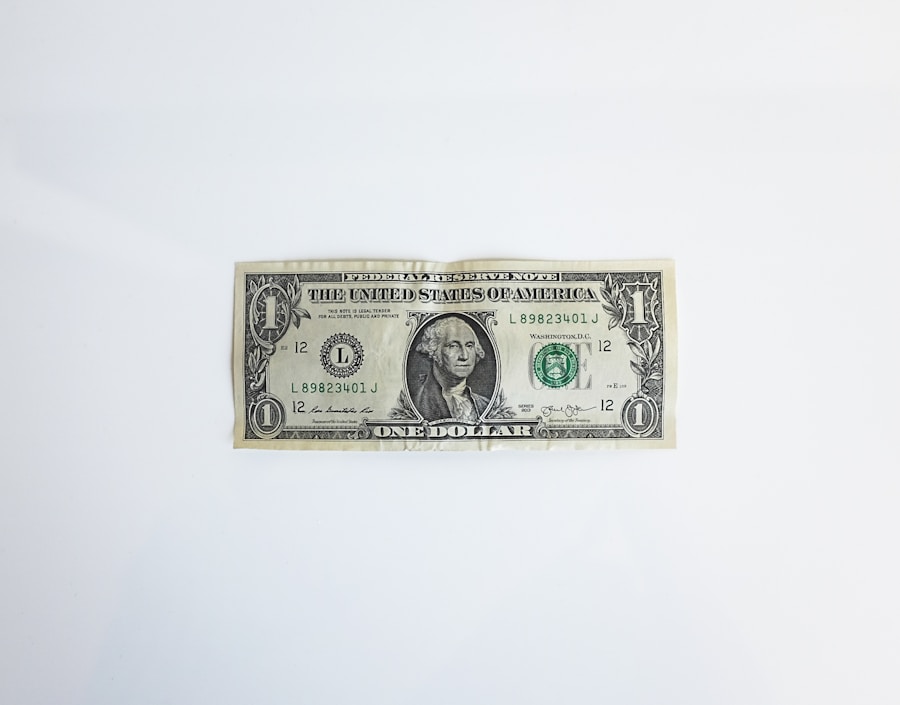 A single us one-dollar bill lying flat on a white surface.