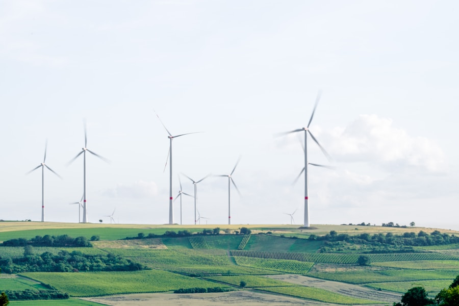 Wind turbines on a hilly landscape with agricultural fields.