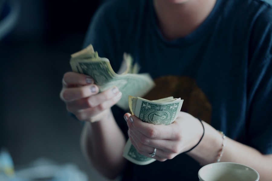 Person counting a stack of cash bills.