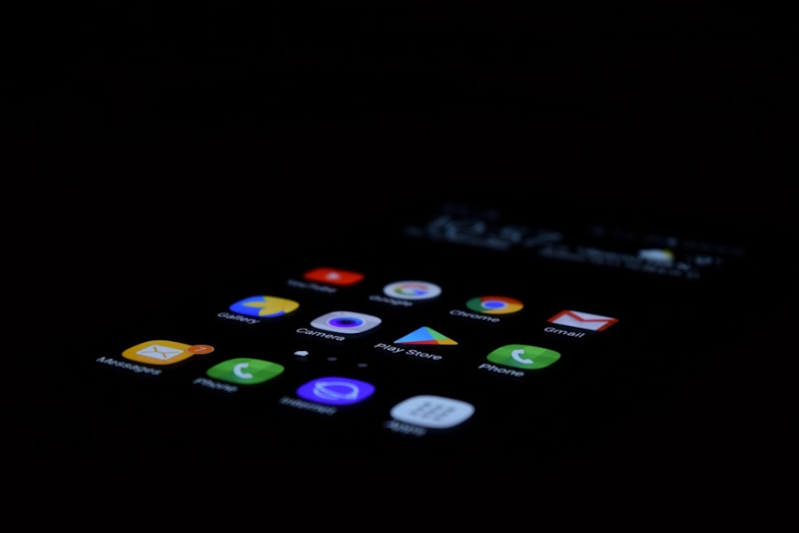 Smartphone screen displaying a selection of colorful app icons in a dark environment.