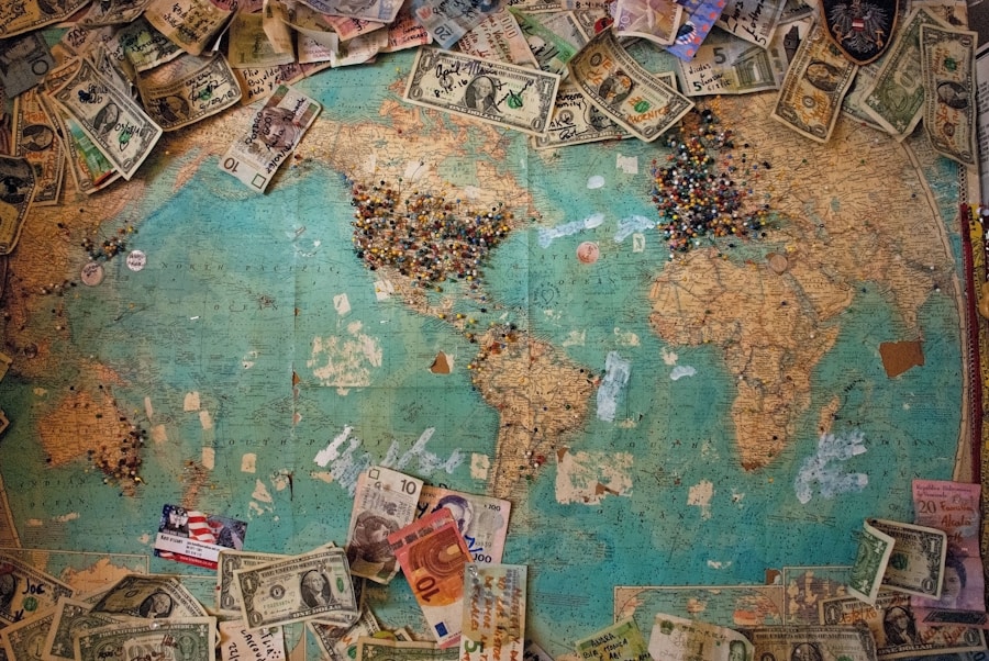 A world map covered with various international banknotes and an abundance of push pins marking locations.