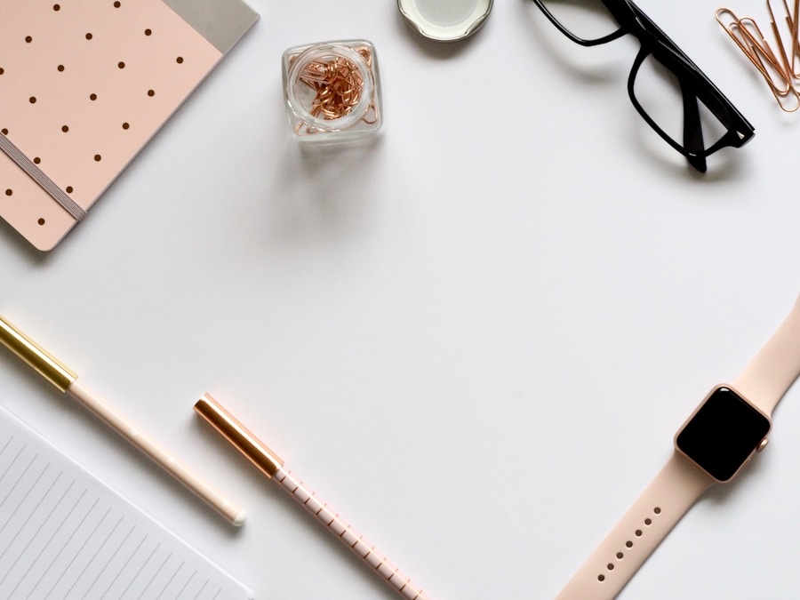 A minimalist workspace with stationery, glasses, and a smartwatch arranged neatly on a white surface depicting quality content