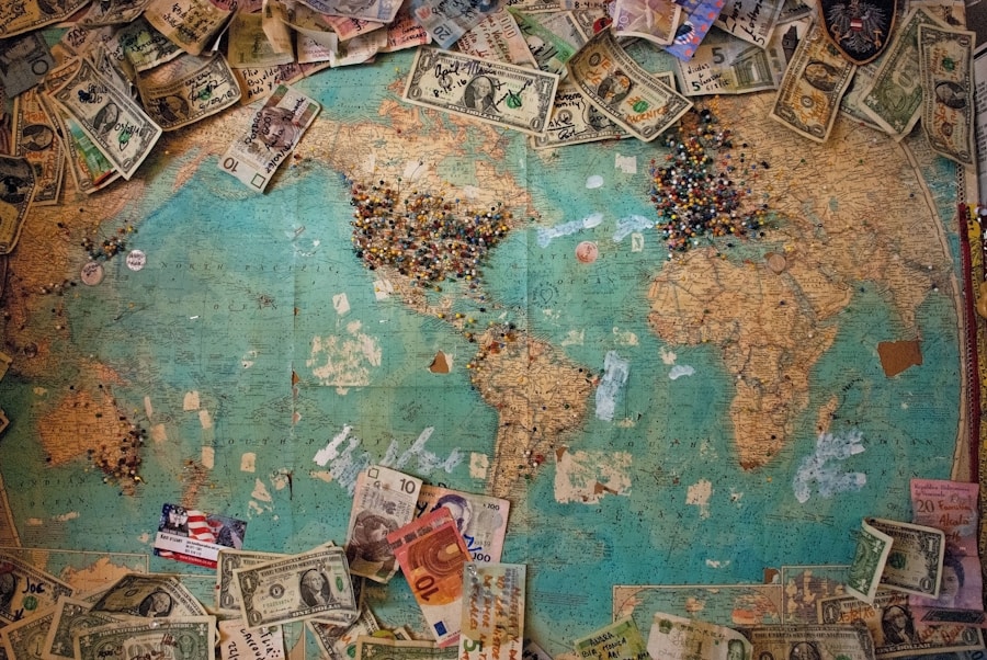 World map covered with various international banknotes and a collection of push pins indicating visited locations depicting data entry jobs that can earn your money around the world