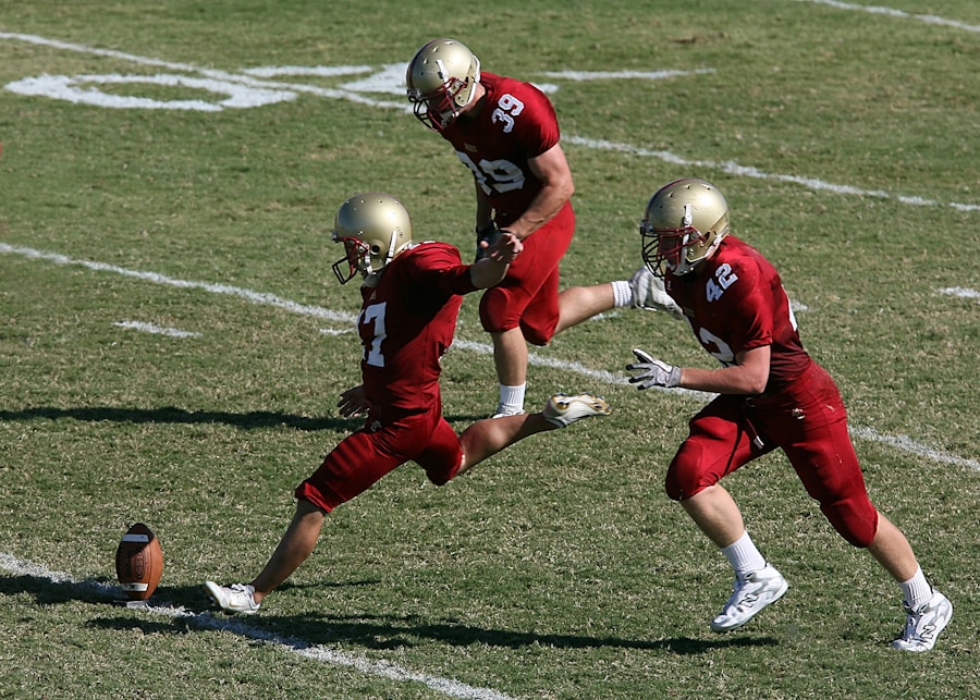 Football player kicking off the ball with teammates nearby.