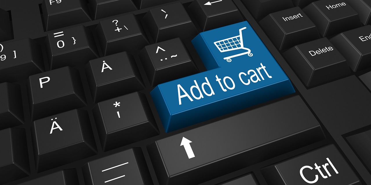 A computer keyboard with a blue "add to cart" key featuring a shopping cart icon depicting e-commerec