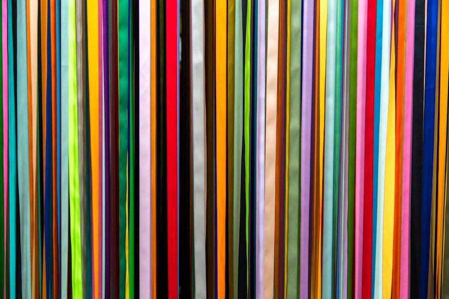 Colorful vertical stripes in various widths and shades, including green, orange, red, blue, yellow, and black, forming a vibrant pattern.