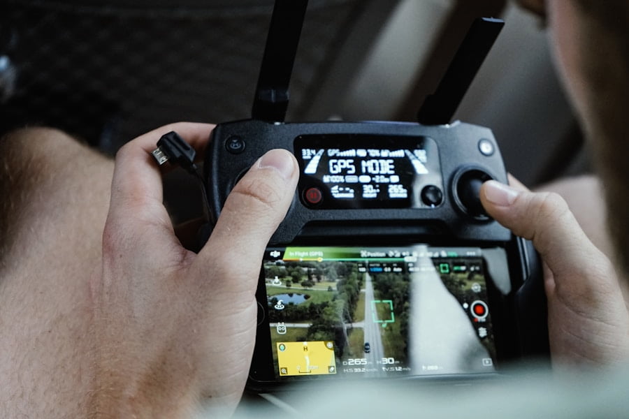 Close-up of a person operating a drone controller, with a display screen showing "GPS Mode" and a live aerial view of a landscape.